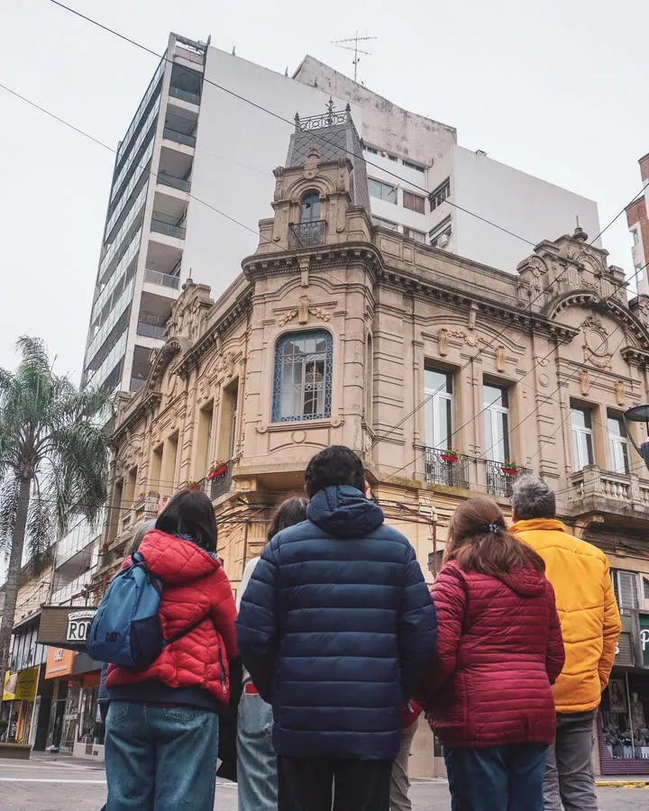 Gente caminando frente a un edificio histórico del centro