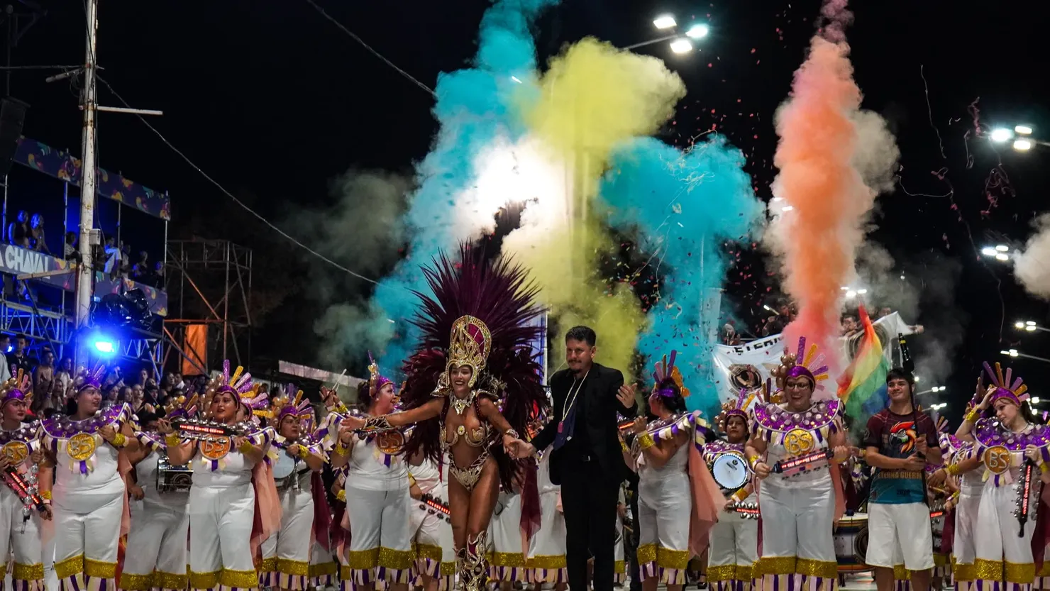 Desfile de carnaval de noche, con humo de colores y tamboriles