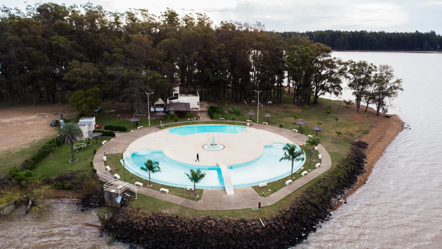 Vista aérea de un balneario con pileta circular junto al río